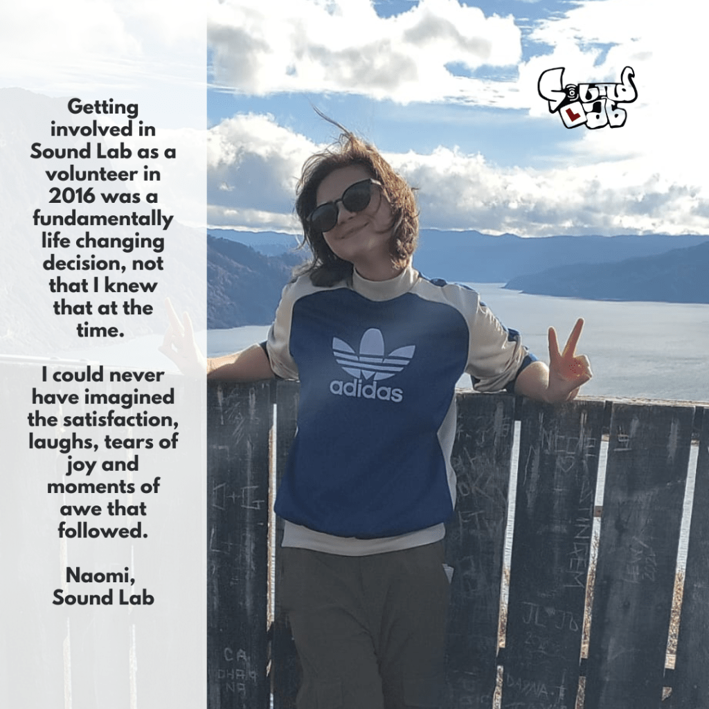 Young person in sunglasses against a backdrop of a Scottish lake. Text reads: Getting involved in Sound Lab as a volunteer in 2016 was a fundamentally life changing decision, not that I knew that at the time. I could never have imagined the satisfaction, laughs, tears of joy and moments of awe that followed. Naomi, Sound Lab